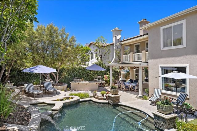 a view of a patio with chairs and a table under an umbrella