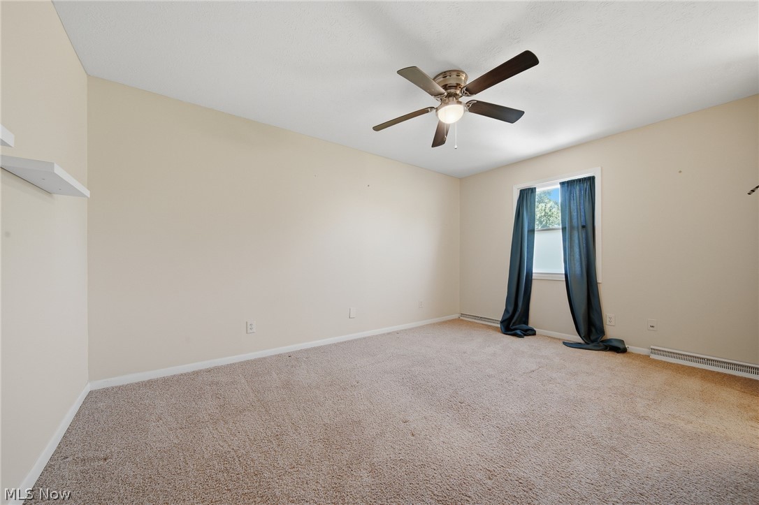 824 South Chillicothe Road, Unit 2 Aurora, OH 44202 - Photo 22 of 42 Carpeted room featuring a ceiling fan with integrated lighting, a single window, and baseboard trim