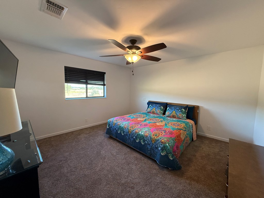 150 Dowling Road West Ingram, TX 78025 - Photo 22 of 33 a bedroom with a bed and a chandelier