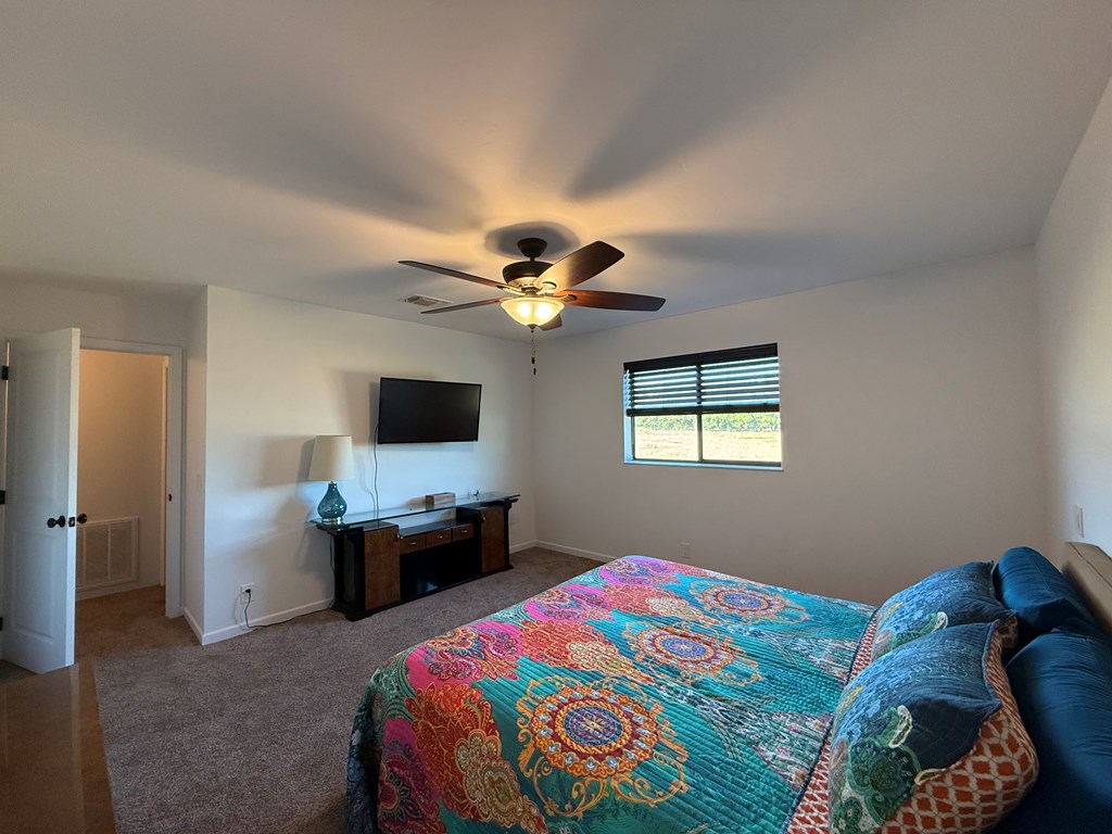 150 Dowling Road West Ingram, TX 78025 - Photo 23 of 33 a bedroom with a bed and a chandelier
