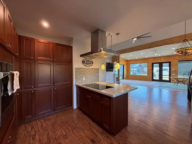 a view of a livingroom with wooden floor and a ceiling fan
