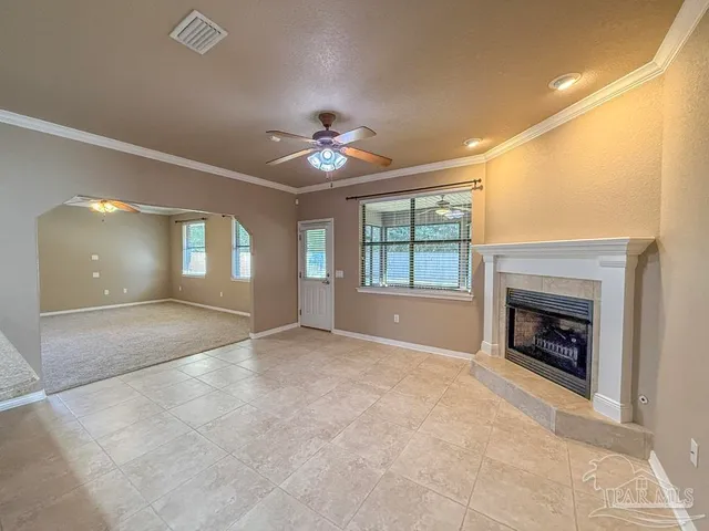 a view of an empty room with a fireplace and a window