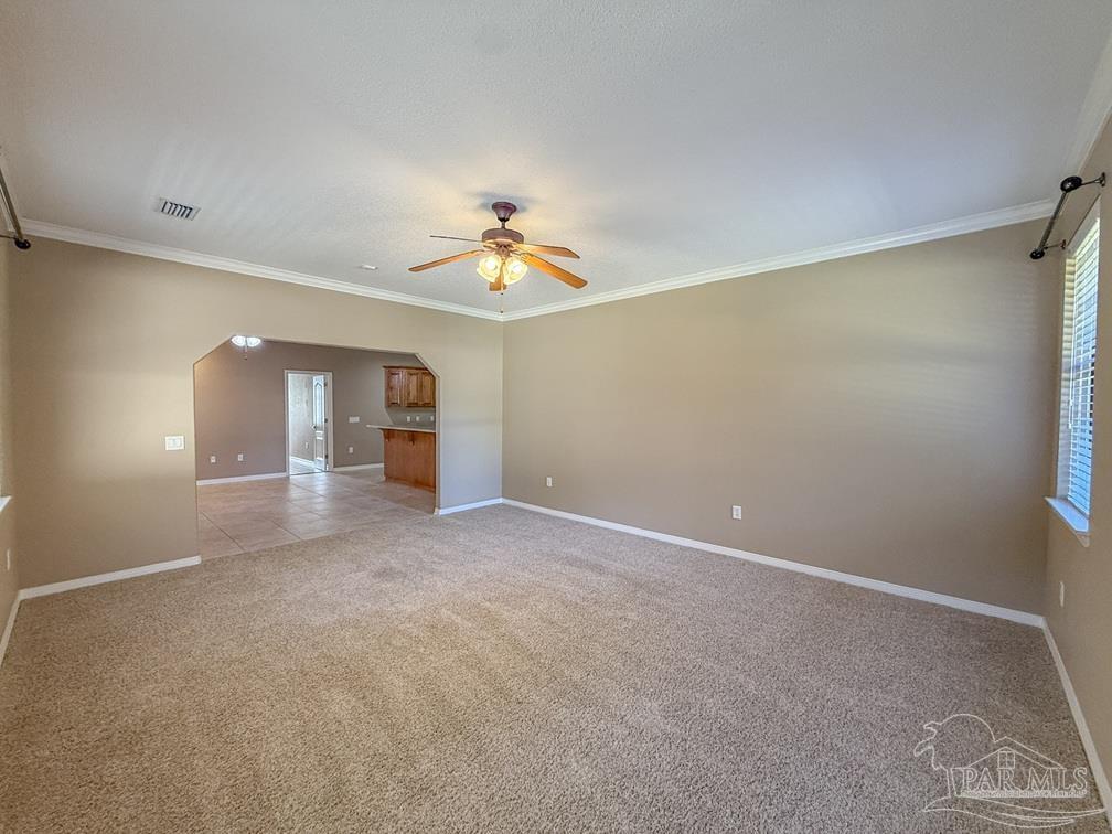 3554 Haley Way Pace, FL 32571 - Photo 15 of 40 an empty room with a chandelier fan and windows