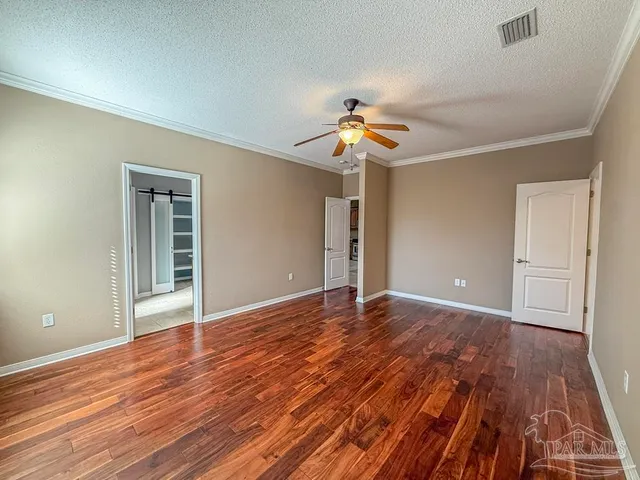 a view of an empty room with wooden floor