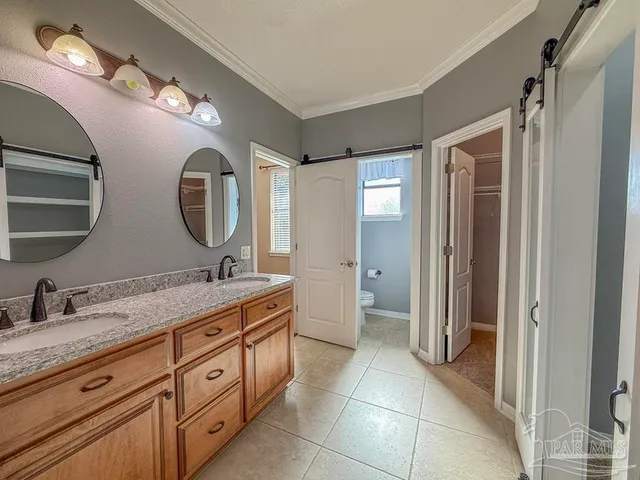 a spacious bathroom with a double vanity sink and a mirror
