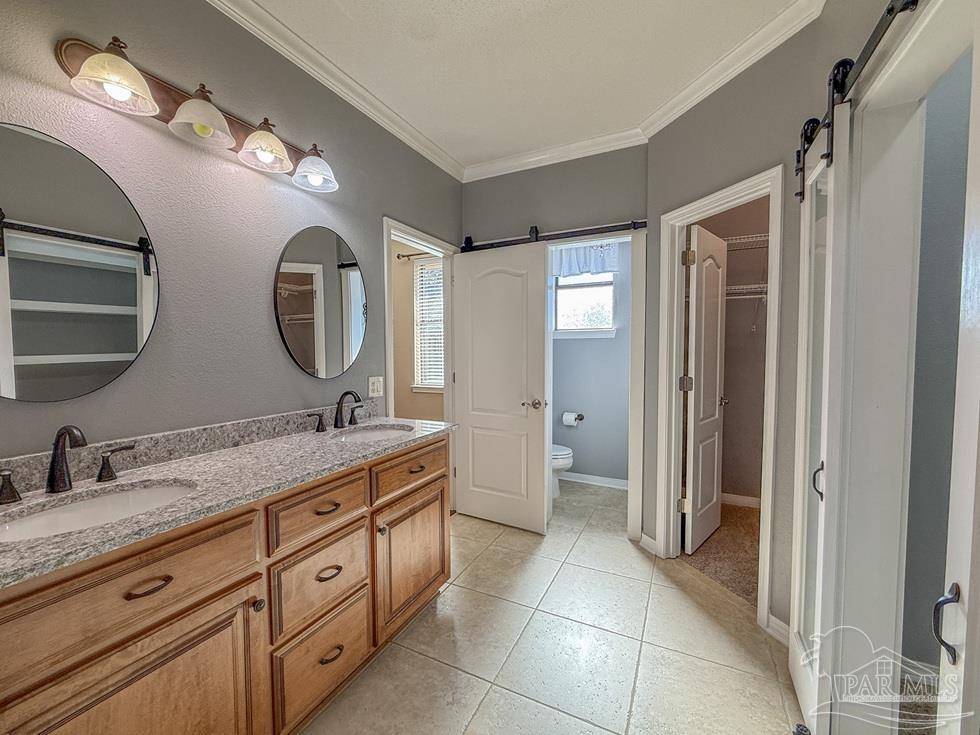 3554 Haley Way Pace, FL 32571 - Photo 22 of 40 a spacious bathroom with a double vanity sink and a mirror