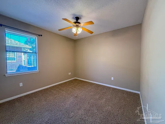 an empty room with closet and a chandelier fan
