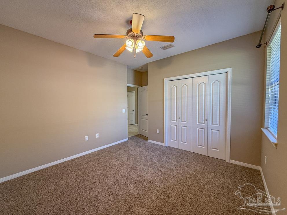3554 Haley Way Pace, FL 32571 - Photo 29 of 40 an empty room with closet and a chandelier fan
