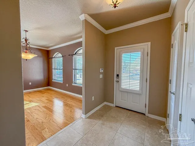 a view of an empty room with window and stairs