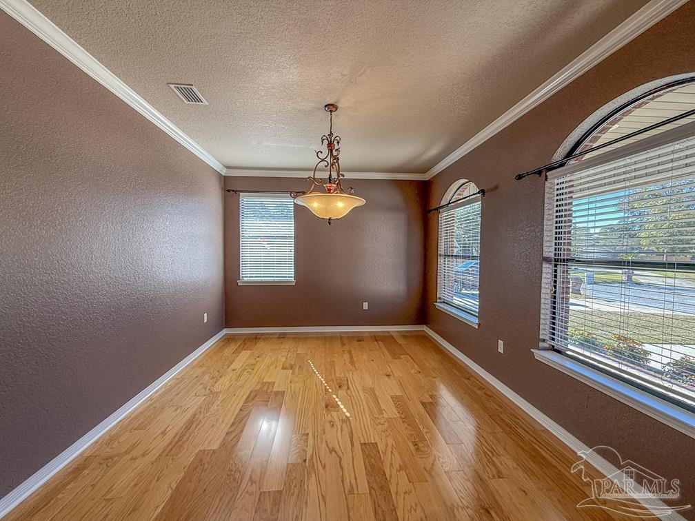 3554 Haley Way Pace, FL 32571 - Photo 6 of 40 a view of an empty room with window and wooden floor