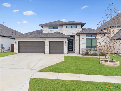 a front view of a house with a garden and yard
