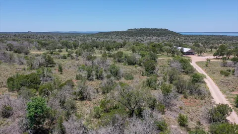 an aerial view of residential houses with outdoor space and trees