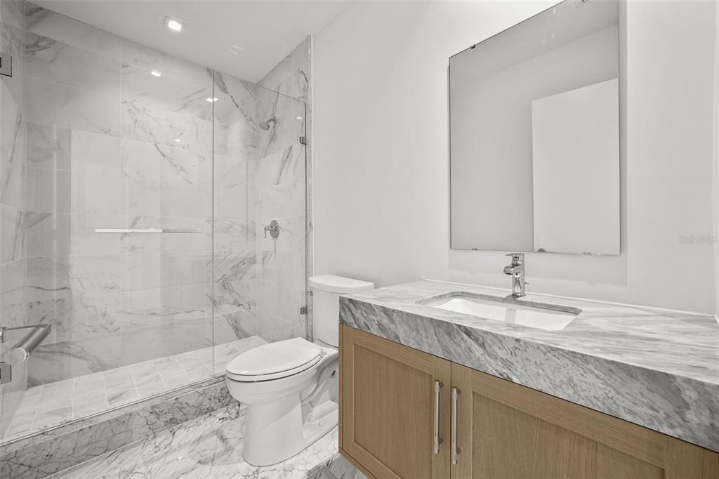 3101 Bayshore Boulevard, Unit 2004 Tampa, FL 33629 - Photo 35 of 64 a bathroom with a granite countertop sink a toilet and shower