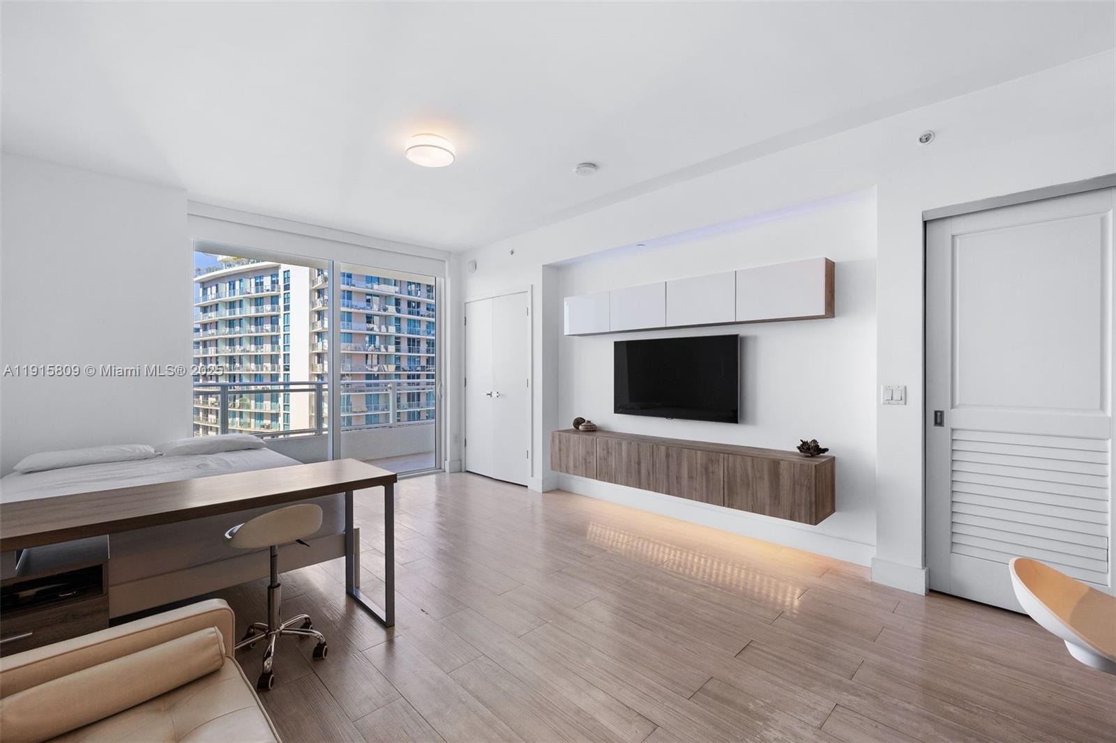 1080 Brickell Avenue, Unit 3705 Miami, FL 33131 - Photo 12 of 32 a view of an empty room with a window and wooden floor