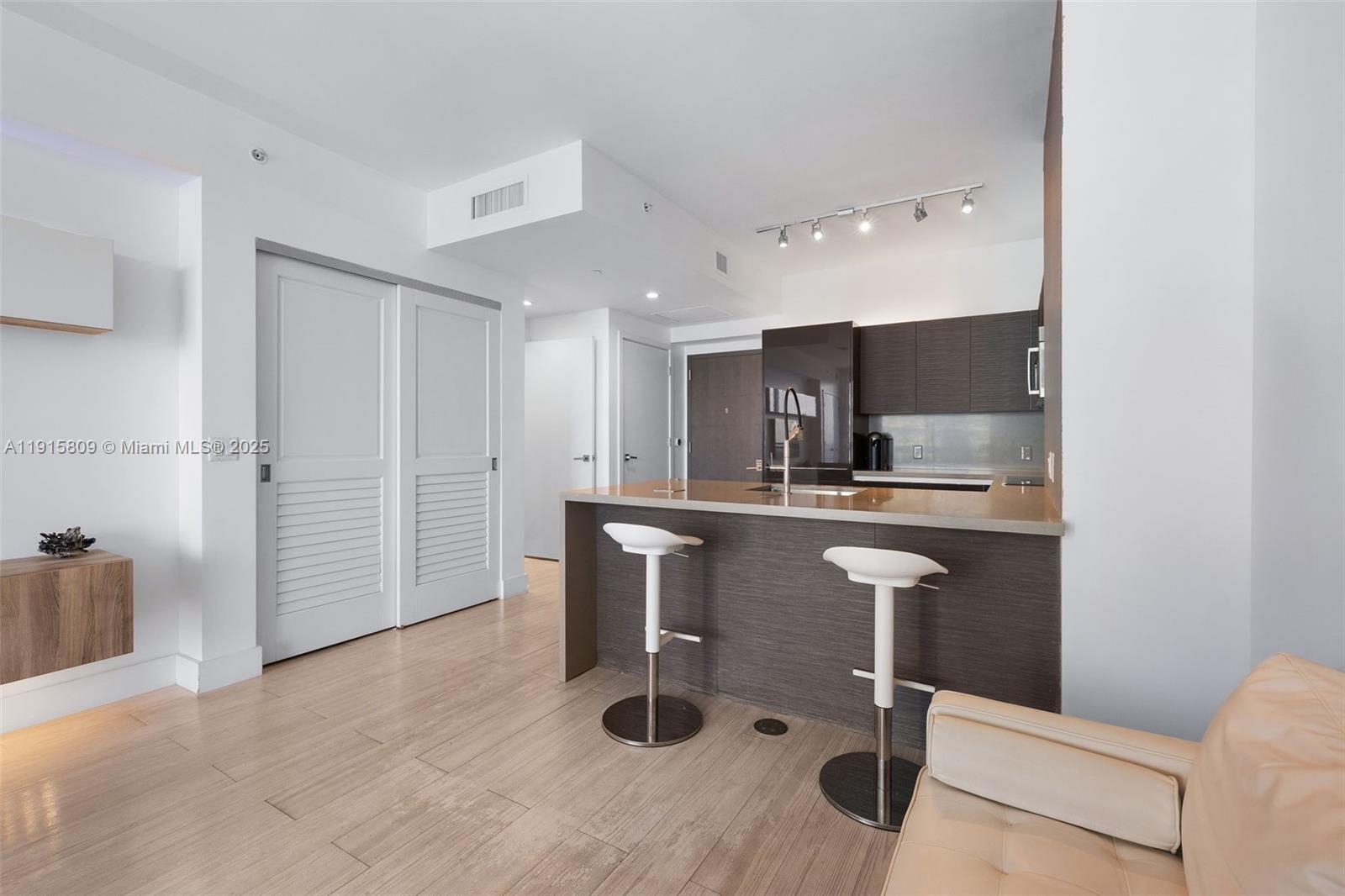 1080 Brickell Avenue, Unit 3705 Miami, FL 33131 - Photo 14 of 32 a kitchen with kitchen island a counter top space a sink stainless steel appliances and cabinets