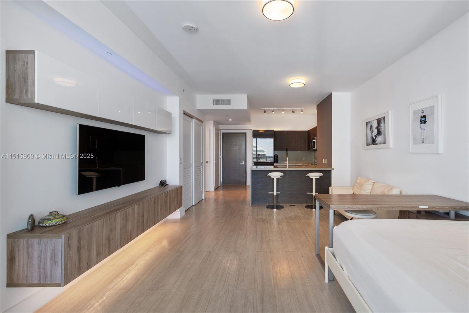 1080 Brickell Avenue, Unit 3705 Miami, FL 33131 - Photo 8 of 32 a living room with stainless steel appliances kitchen island furniture and a flat screen tv