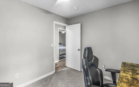 an empty room with a window and chandelier fan