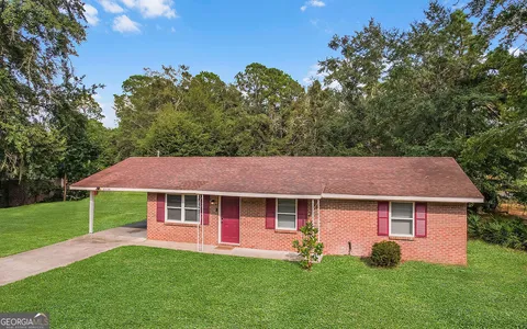 a aerial view of a house with table and chairs under an umbrella