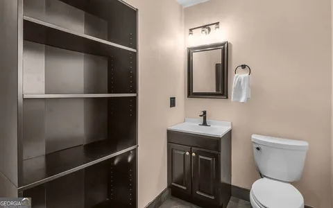 a bathroom with a toilet a sink and mirror