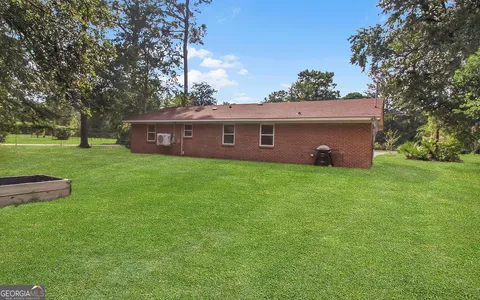 a front view of a house with yard and green space