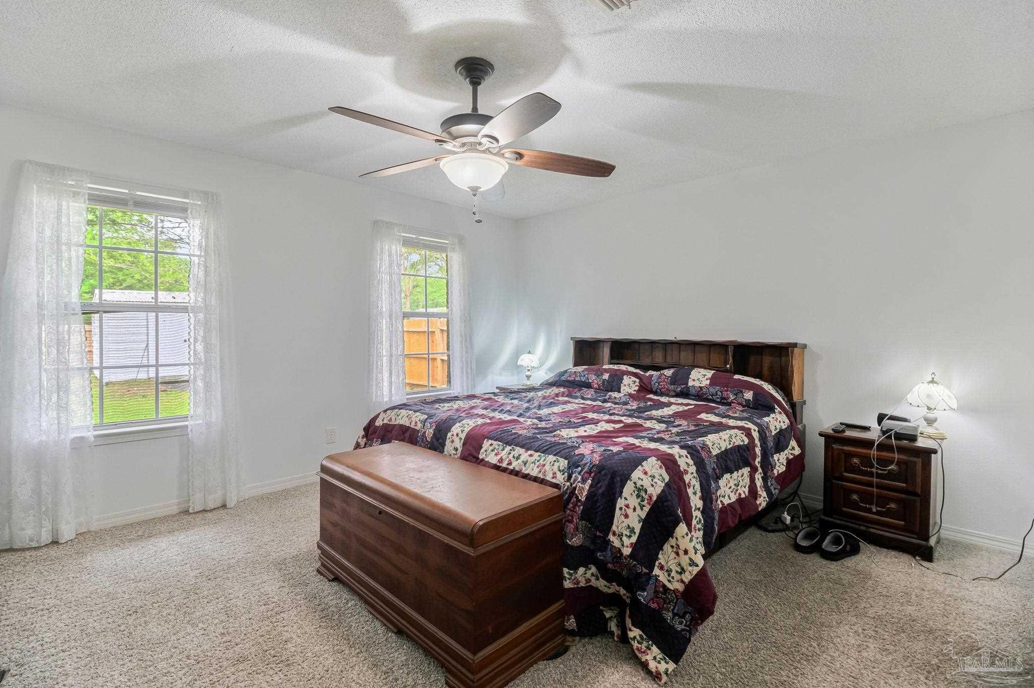 5691 Berrybrook Circle Pace, FL 32571 - Photo 12 of 22 a bedroom with a bed and a chandelier