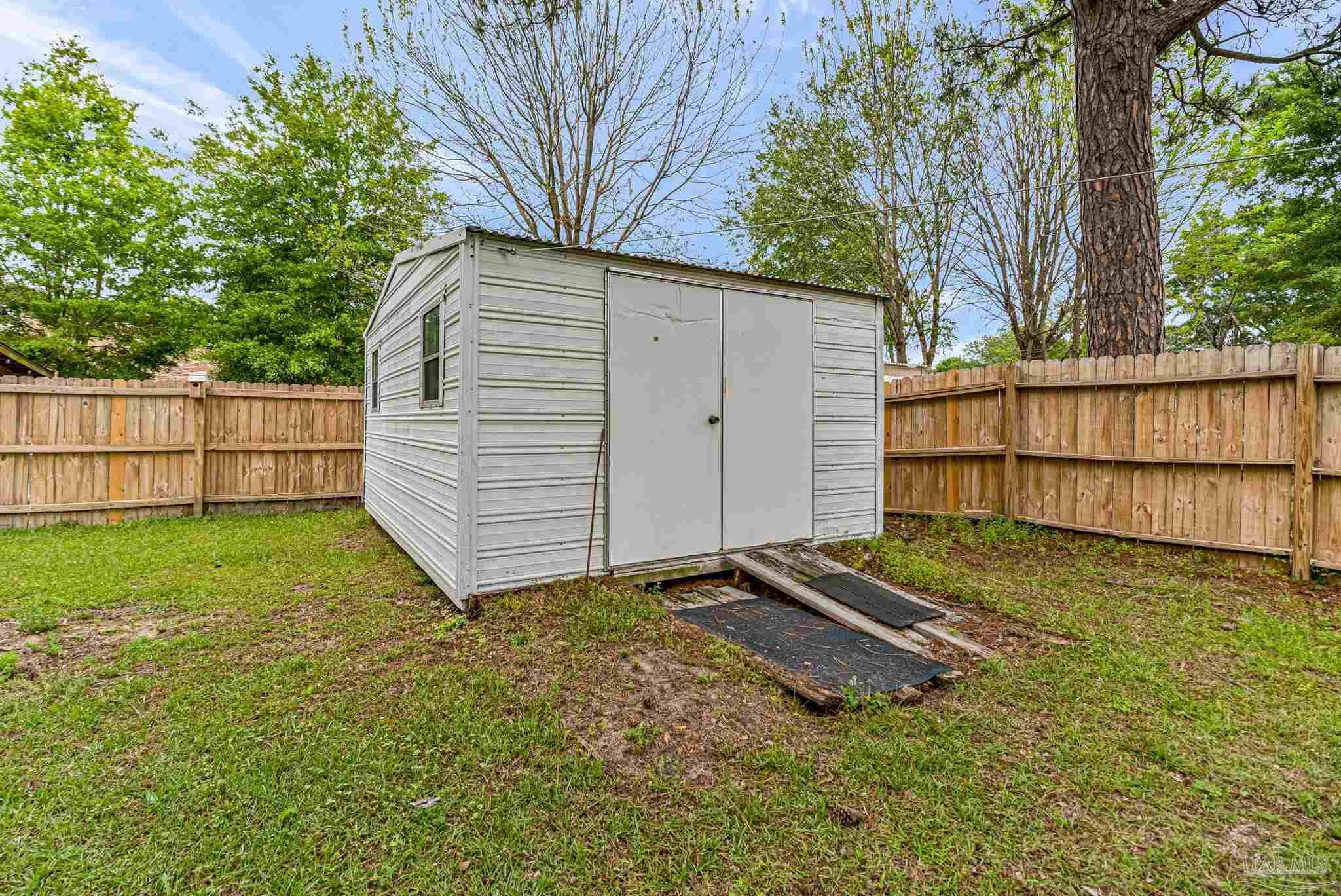 5691 Berrybrook Circle Pace, FL 32571 - Photo 19 of 22 a backyard of a house with a large tree and wooden fence