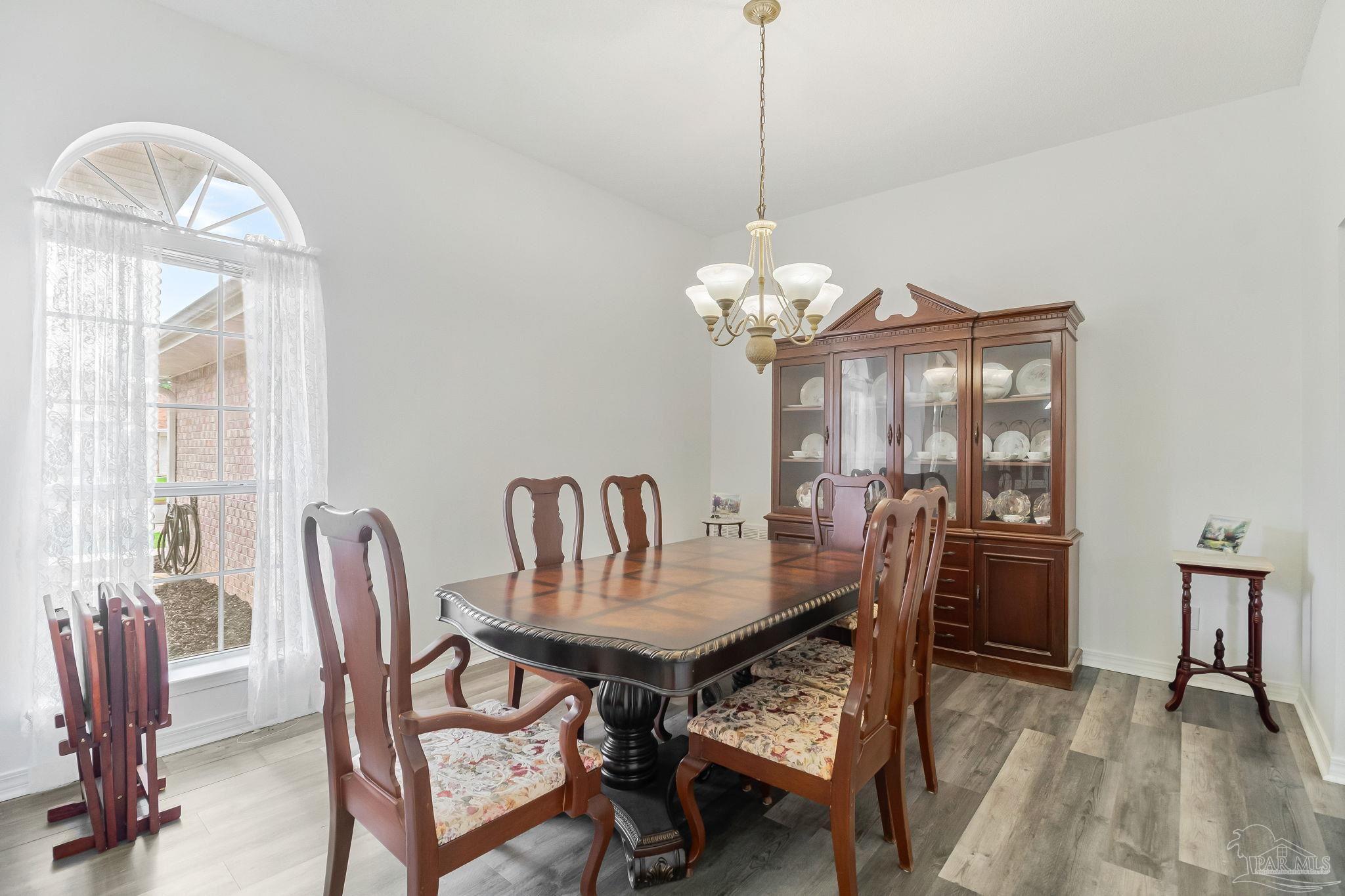 5691 Berrybrook Circle Pace, FL 32571 - Photo 3 of 22 a dining room with furniture a chandelier and wooden floor