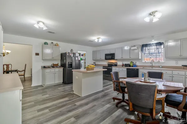 a kitchen with a sink a counter top space stainless steel appliances and cabinets