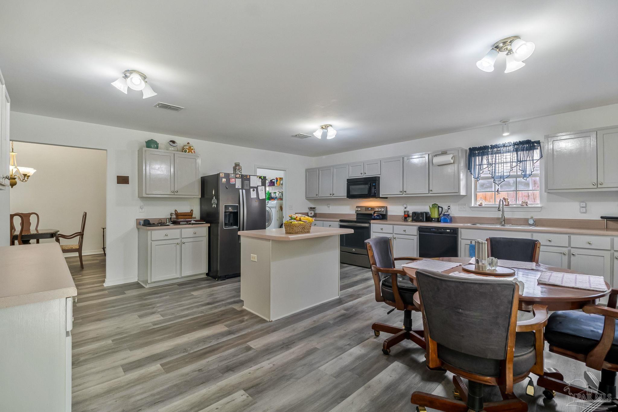 5691 Berrybrook Circle Pace, FL 32571 - Photo 7 of 22 a kitchen with a sink a counter top space stainless steel appliances and cabinets