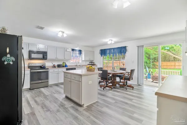 a kitchen with white cabinets and stainless steel appliances