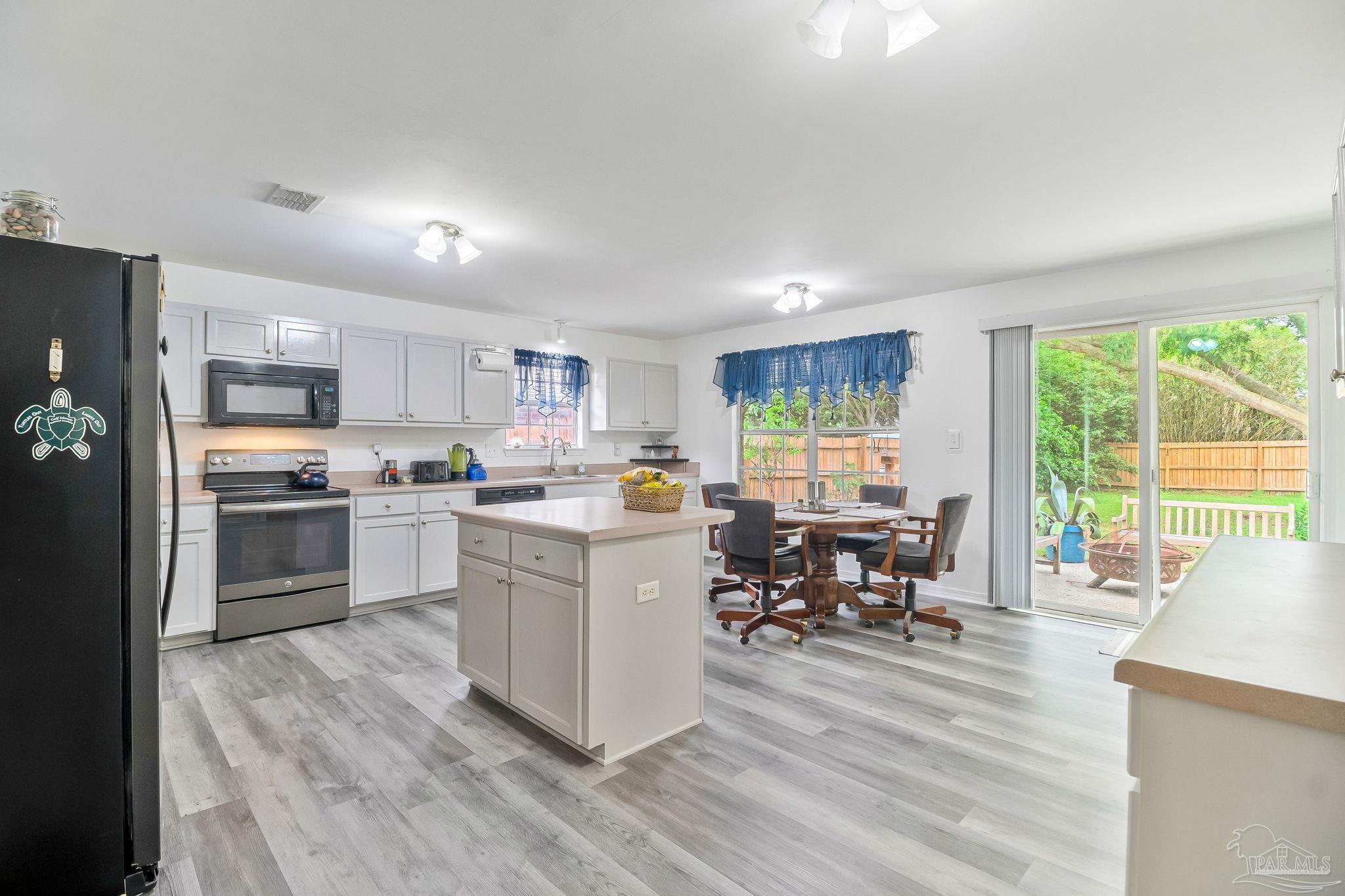 5691 Berrybrook Circle Pace, FL 32571 - Photo 8 of 22 a kitchen with white cabinets and stainless steel appliances