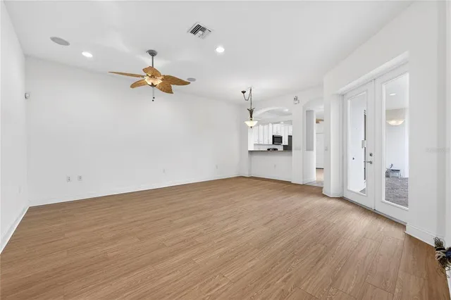 an empty room with wooden floor and windows
