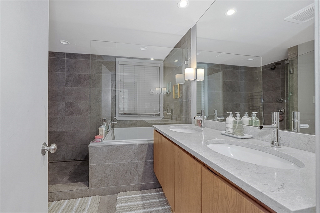70 Clarendon Street, Unit 1 Boston, MA 02116 - Photo 13 of 19 a bathroom with a double vanity sink a mirror and a bathtub