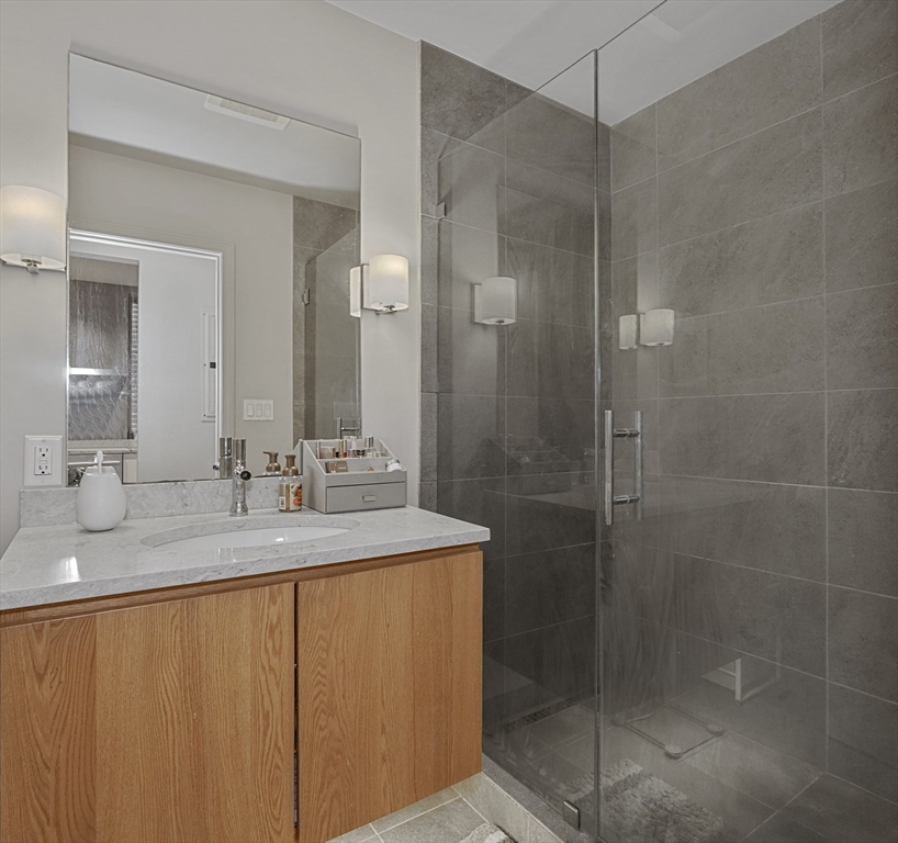 70 Clarendon Street, Unit 1 Boston, MA 02116 - Photo 6 of 19 a bathroom with a granite countertop sink a mirror and shower