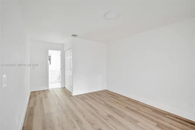 a view of a room with wooden floor and white walls
