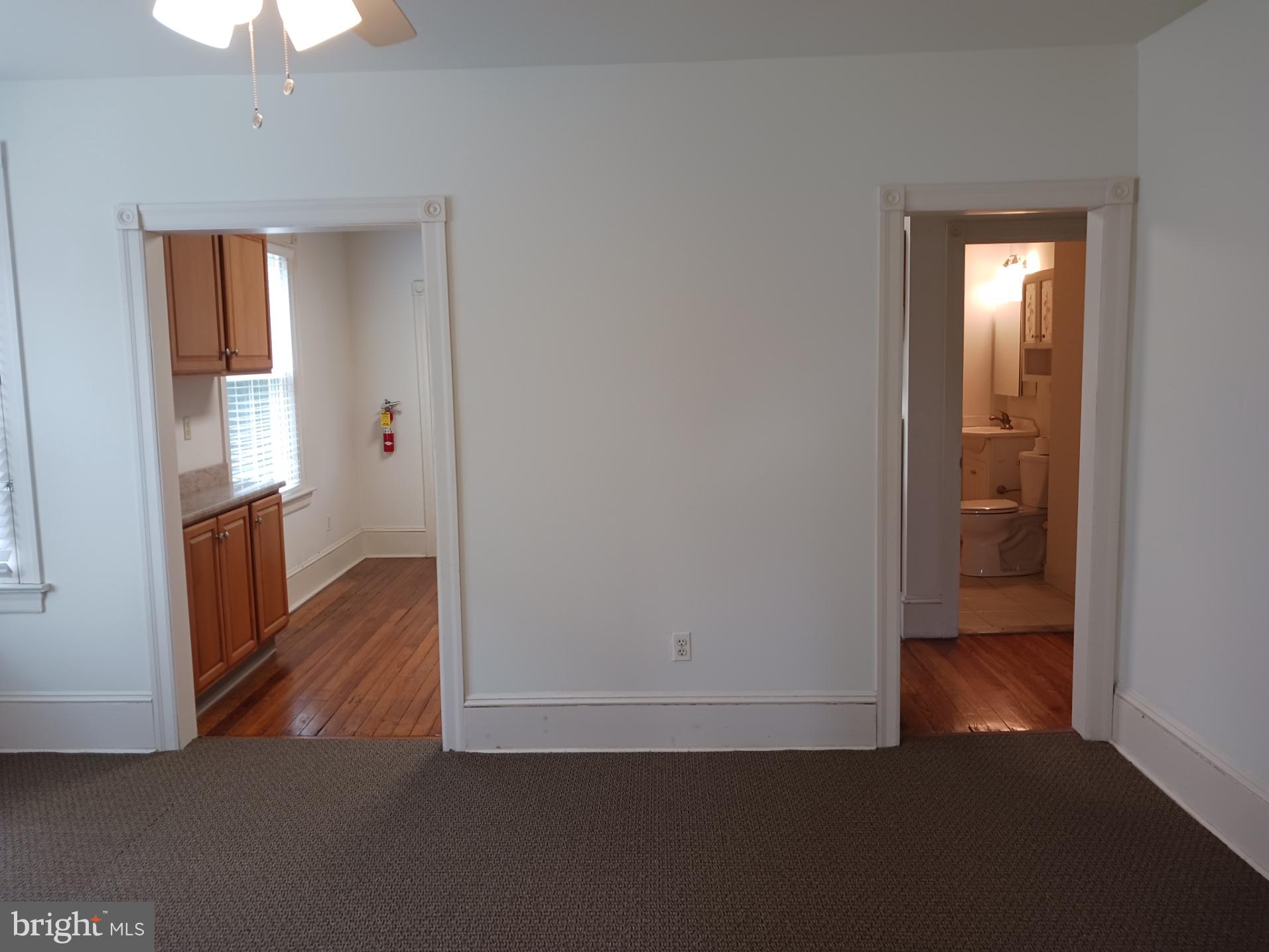 58 Darby Road, Unit 1 Paoli, PA 19301 - Photo 7 of 16 an empty room with wooden floor mirror and windows