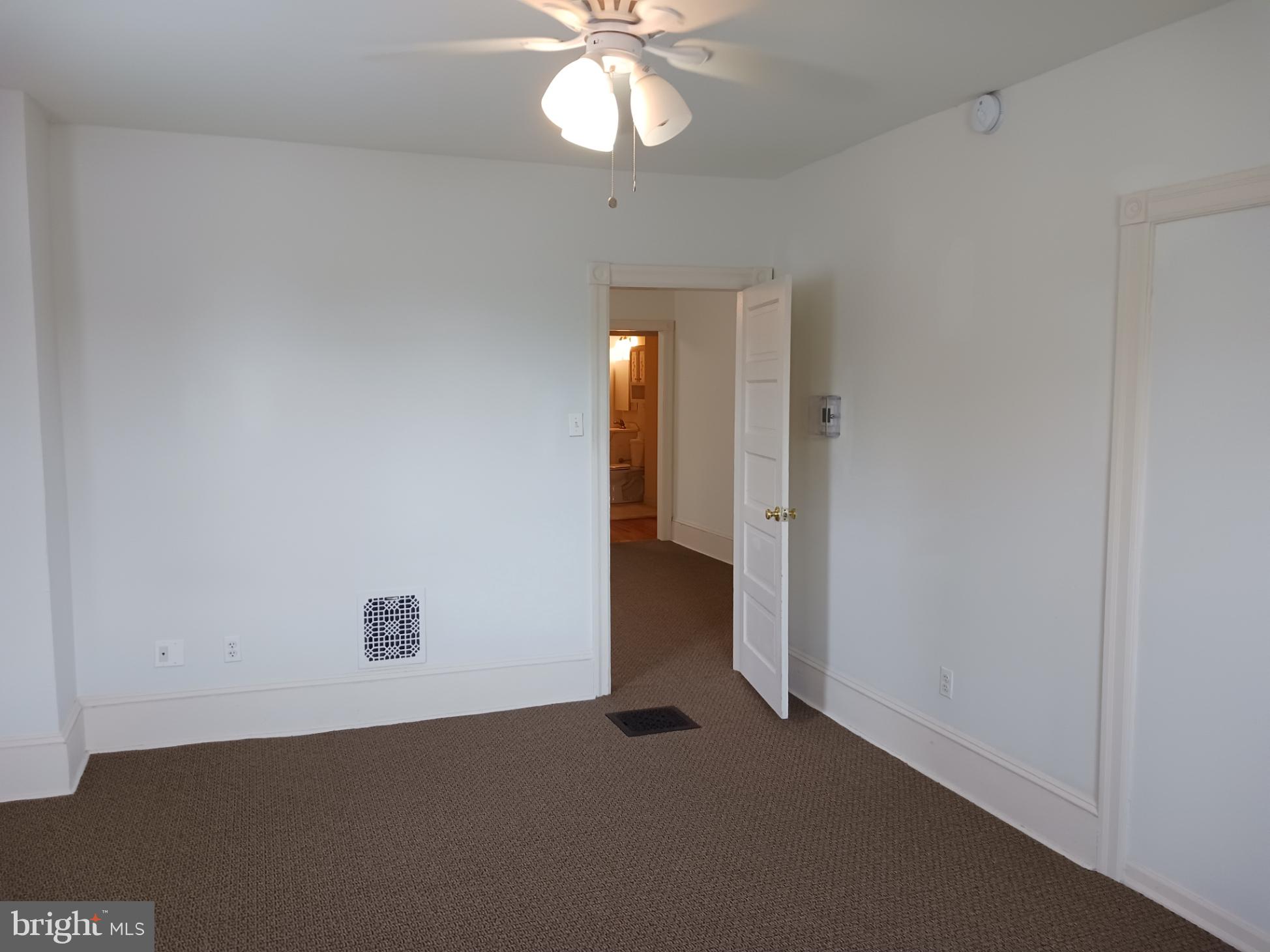 58 Darby Road, Unit 1 Paoli, PA 19301 - Photo 10 of 16 an empty room with a chandelier fan and windows