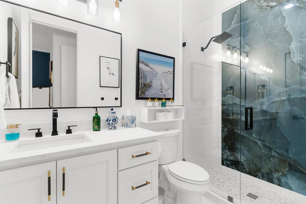 1307 Silverlake Road McKinney, TX 75072 - Photo 20 of 33 a bathroom with a toilet a sink a mirror a vanity and shower