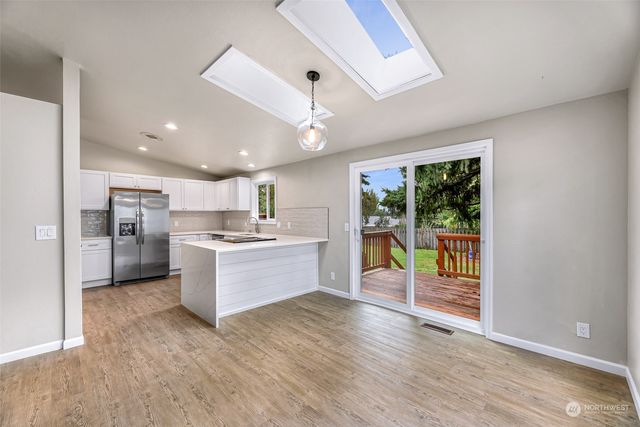 a large kitchen with a large window and stainless steel appliances