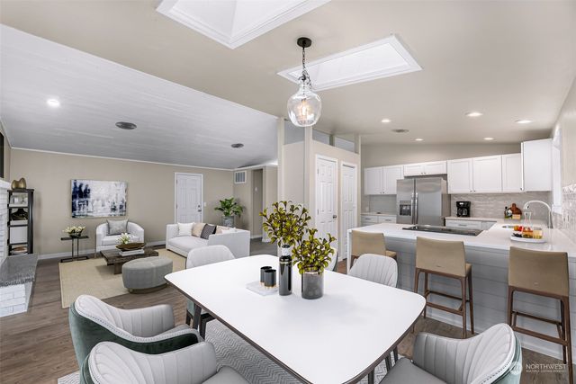 a kitchen with kitchen island stainless steel appliances sink dining table and chairs