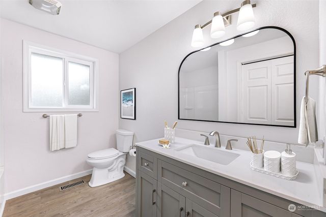 a bathroom with a bathtub shower sink vanity and toilet