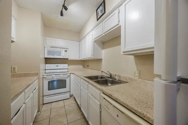 a kitchen with a sink stove top oven and cabinets