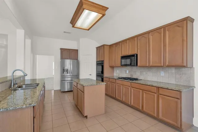 a kitchen with stainless steel appliances granite countertop a sink stove and cabinets