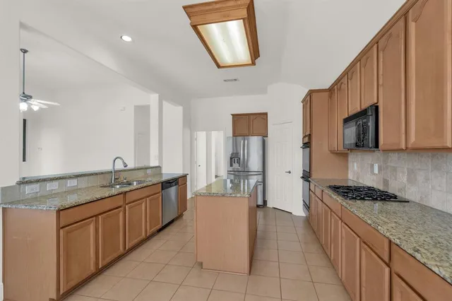 a kitchen with stainless steel appliances granite countertop a stove and a sink