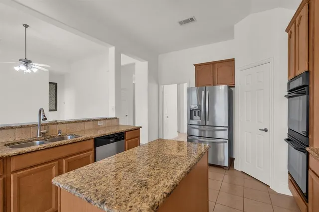 a kitchen with stainless steel appliances granite countertop a sink refrigerator and microwave