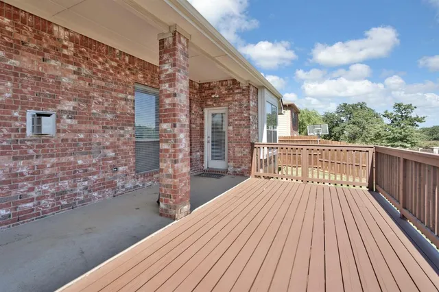 a view of a balcony with wooden floor and fence