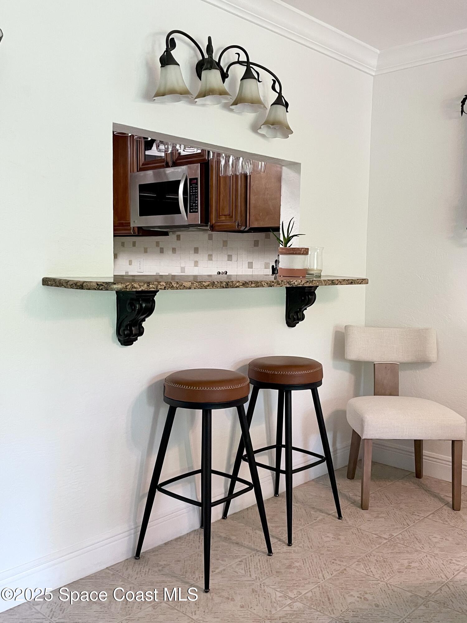 7 Cove Road Melbourne Beach, FL 32951 - Photo 11 of 55 a kitchen with stainless steel appliances kitchen island a stove a table and chairs in it