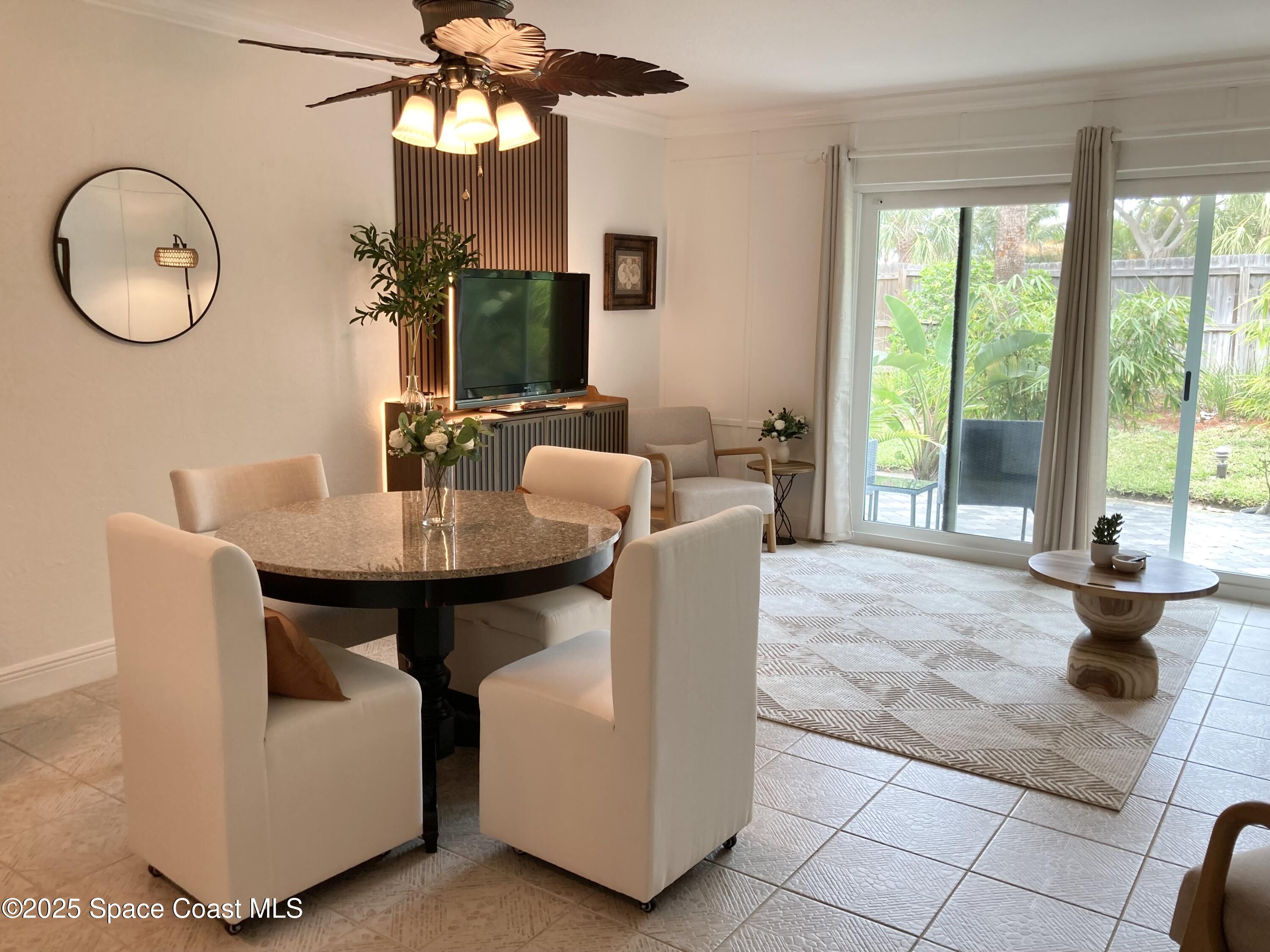 7 Cove Road Melbourne Beach, FL 32951 - Photo 13 of 55 a dining room with wooden floor a chandelier a glass table and chairs