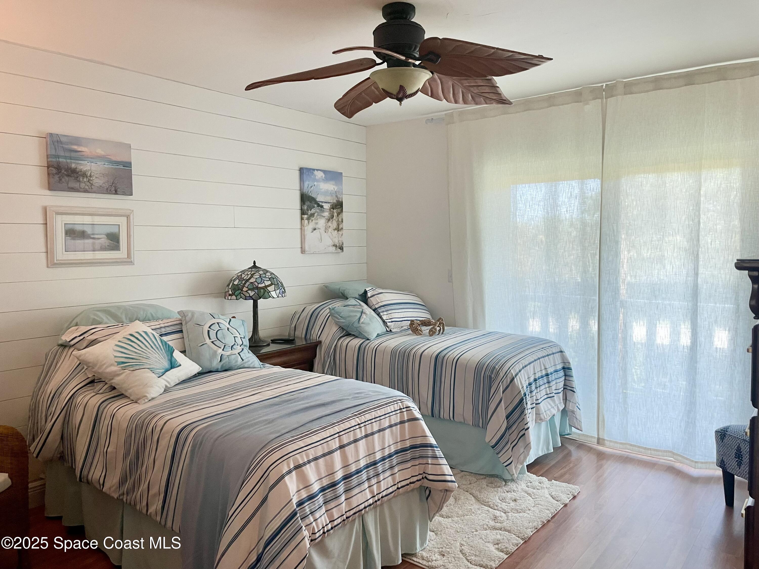 7 Cove Road Melbourne Beach, FL 32951 - Photo 19 of 55 a bedroom with two beds and a chandelier