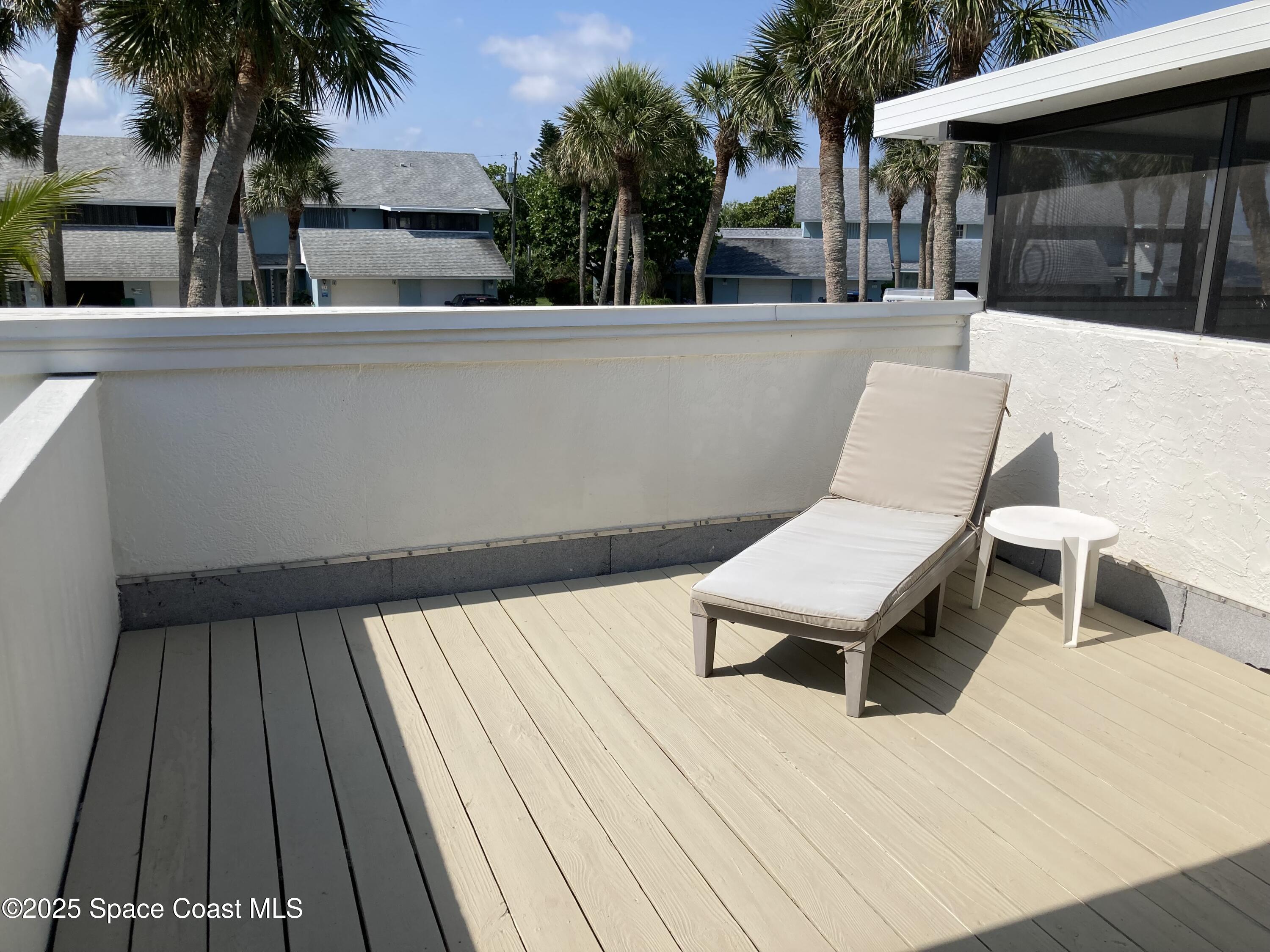 7 Cove Road Melbourne Beach, FL 32951 - Photo 28 of 55 a view of a patio with table and chairs with wooden floor and fence